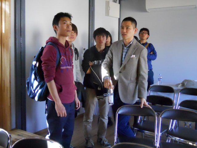 来場した学生から質問を受けるexpoの山根氏(右)